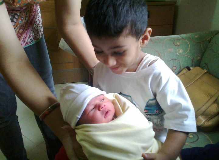 A little boy holding his baby sister