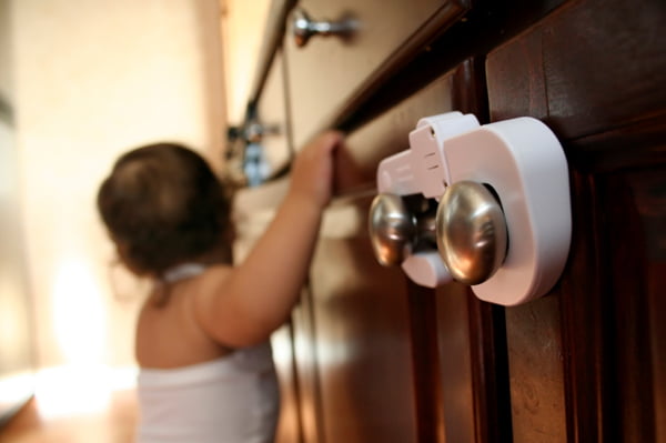 Child proofing your house - Baby holding on to the drawer