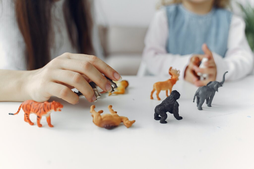 A little girl playing with dinosaurs - Role Of Play In Early Childhood Education